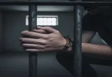 म्यांमार: स्वतंत्रता दिवस पर 6,186 कैदियों की रिहाई का ऐलान, चुनाव प्रक्रिया के बीच सैन्य सरकार का महत्वपूर्ण कदम जेल की सलाखों के पीछे हथकड़ी लगाए कैदी का हाथ, म्यांमार में स्वतंत्रता दिवस पर कैदियों की रिहाई से जुड़ा प्रतीकात्मक चित्र